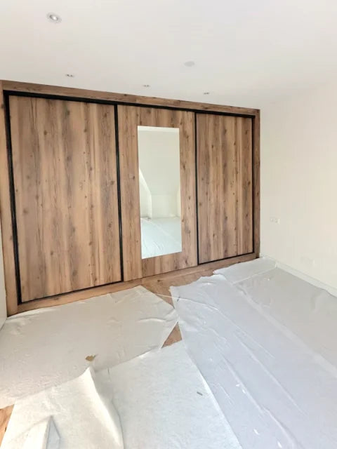 Kasten met houten schuiffronten — Houtkleurige schuiffronten, spiegelvlakken en laden.