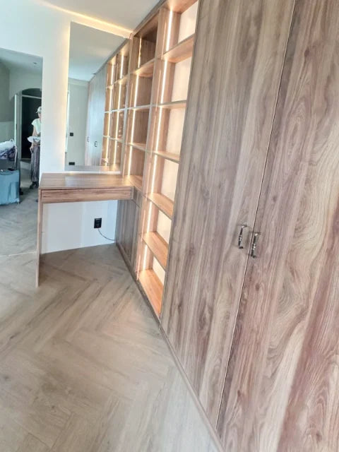 Houtkleurige kasten en laden — Open vakken, laden en verlichte kastonderdelen.