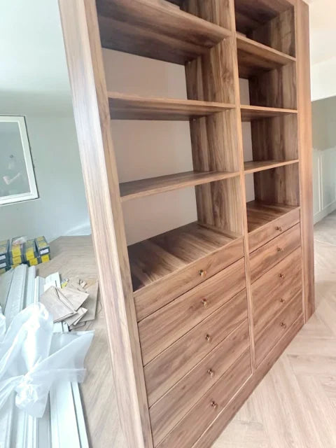 Houtkleurige kasten en laden — Open vakken, laden en verlichte kastonderdelen.