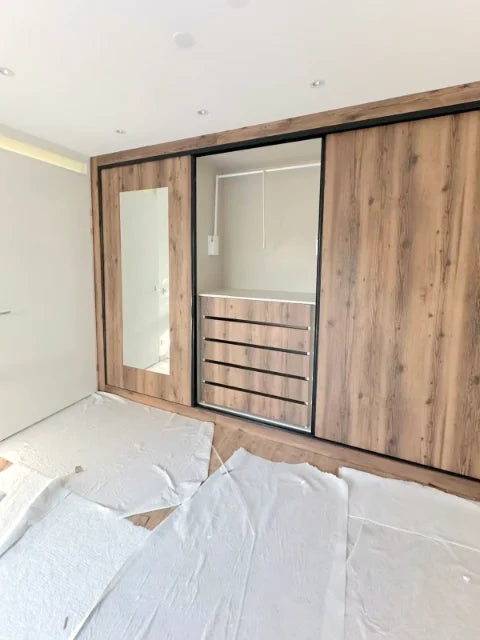 Kasten met houten schuiffronten — Houtkleurige schuiffronten, spiegelvlakken en laden.