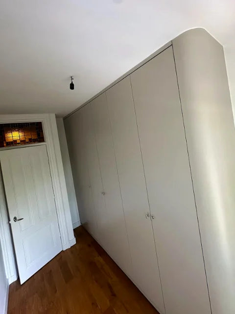 Lichte garderobekasten — Lichte kastfronten met hangruimte, legplanken en laden.