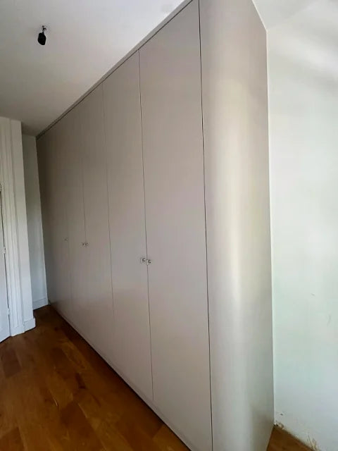 Lichte garderobekasten — Lichte kastfronten met hangruimte, legplanken en laden.