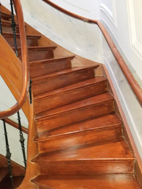 Detail van de gelakte houten trap en leuning.
