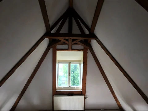 Schilderwerk onder de kap — Lichte vlakken rond zichtbare houten balken.