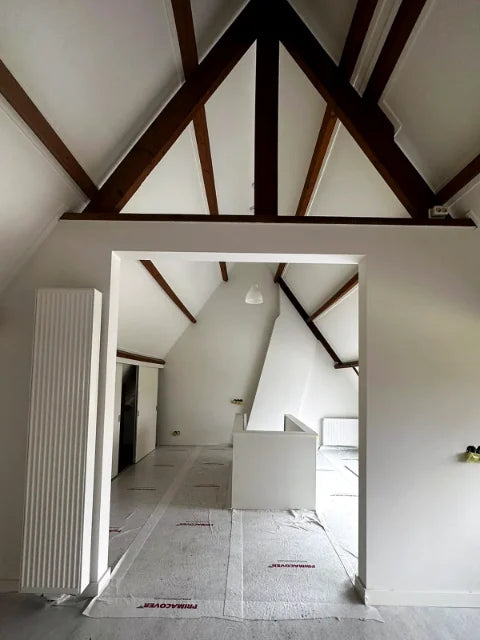 Schilderwerk onder de kap — Lichte vlakken rond zichtbare houten balken.