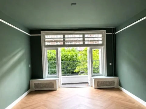 Groene wanden en plafond — Groentinten met wit houtwerk en sierlijsten.